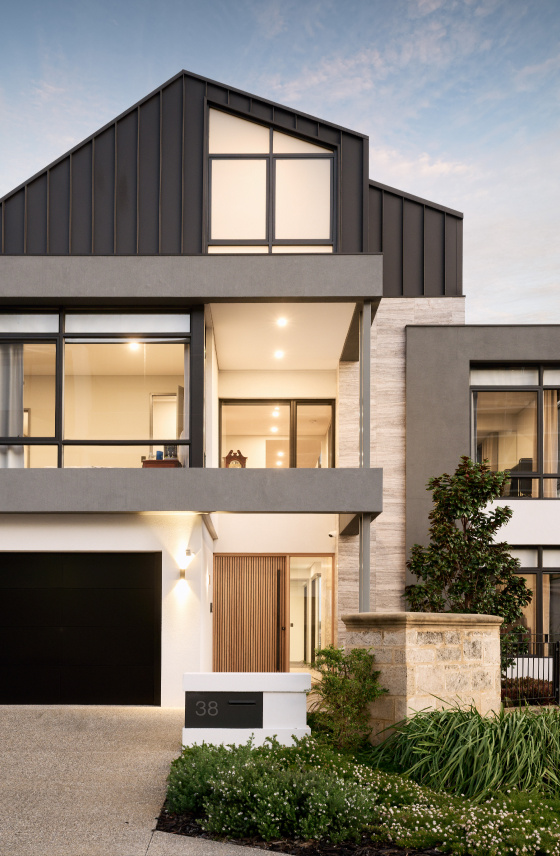 Three-storey custom home on Mathieson Avenue featuring a limestone retaining wall, covered balconies and expansive glazing.
