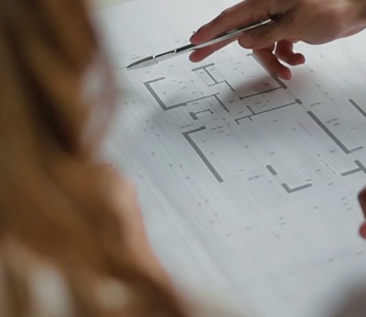 Close-up of architectural floor plans being reviewed during the custom home design process.
