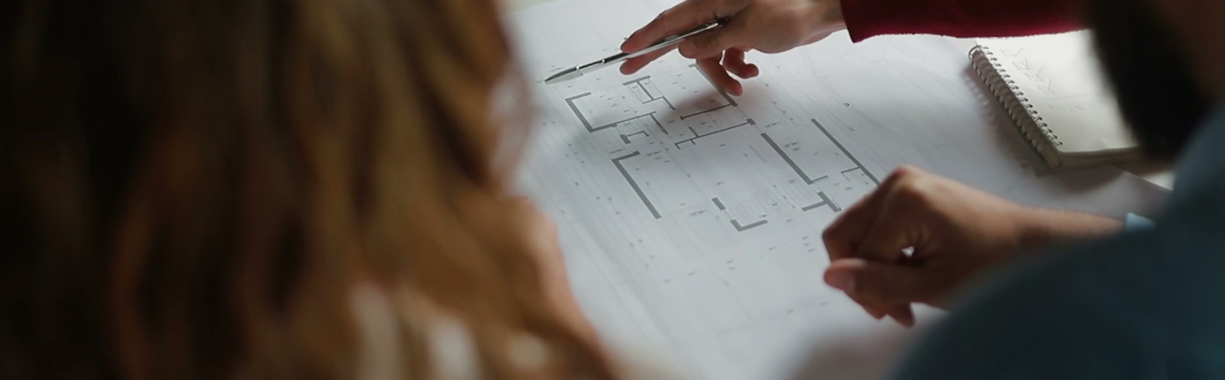 Close-up of architectural floor plans being reviewed during the custom home design process.