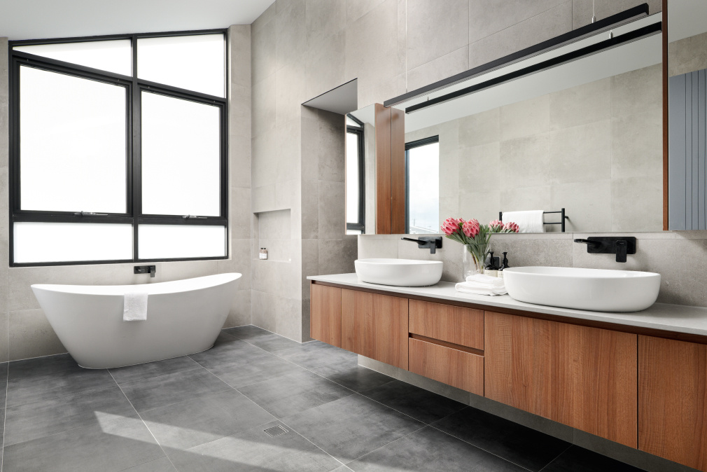 Mathieson Avenue custom home bathroom featuring a freestanding bath, stone finishes and large windows.