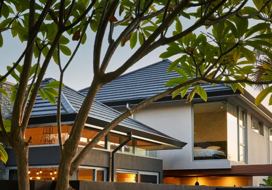 Exterior architectural detail featuring intersecting rooflines, timber finishes and surrounding greenery.