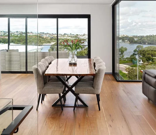Light-filled custom home living area featuring large windows, contemporary furnishings and expansive river views.