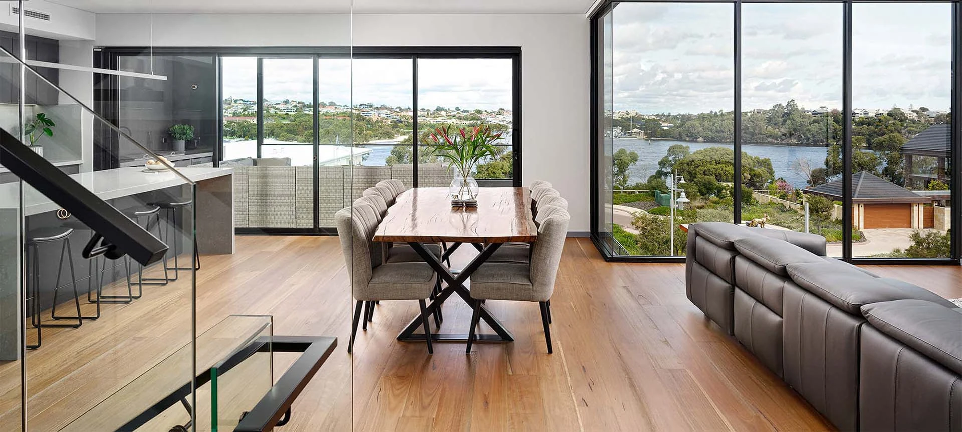 Light-filled custom home living area featuring large windows, contemporary furnishings and expansive river views.