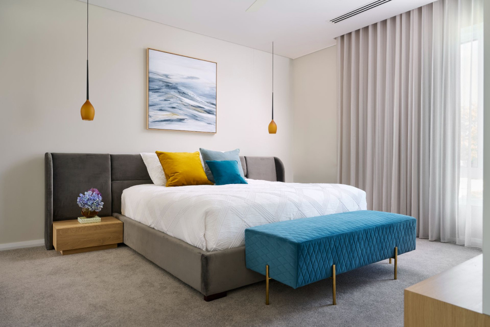 Bedroom at The Grove in Wembley featuring an upholstered bed, pendant lighting and full-height curtains.