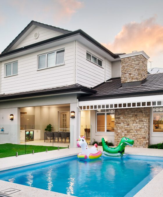 Two-storey custom home on Lombardy Street featuring a swimming pool, stone cladding and landscaped outdoor areas.