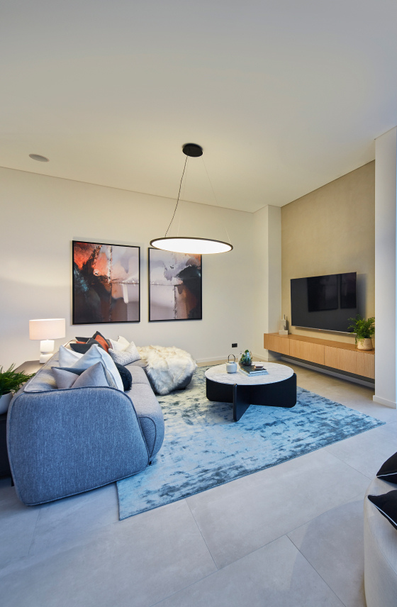 Living area featuring large-format porcelain floor tiles, a contemporary fireplace and decorative pendant lighting.
