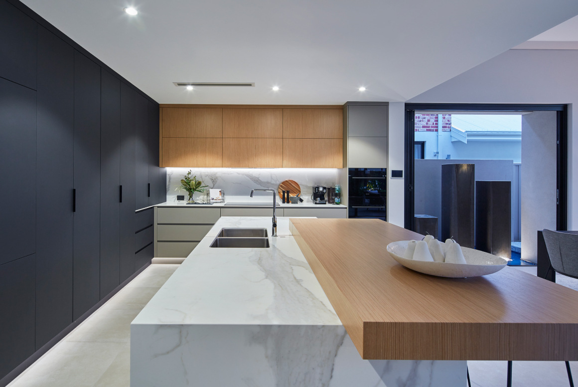 Custom home kitchen at Redmond Street featuring timber cabinetry, stone benchtops and integrated appliances.