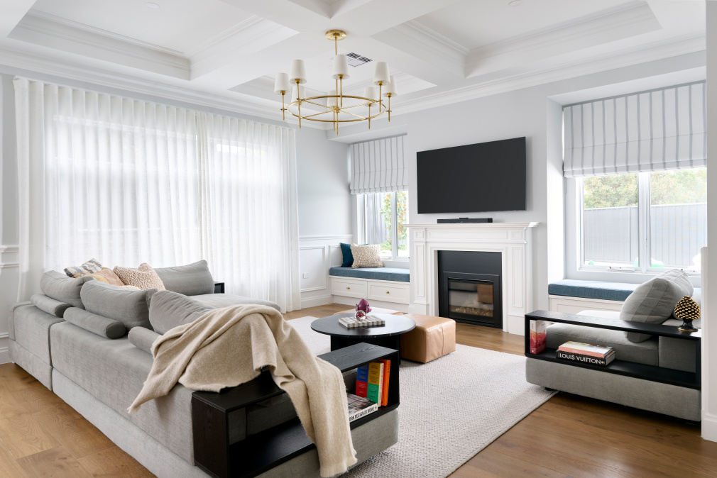 Light-filled living room at Lombardy Street featuring white wall panelling, a fireplace and contemporary furniture.