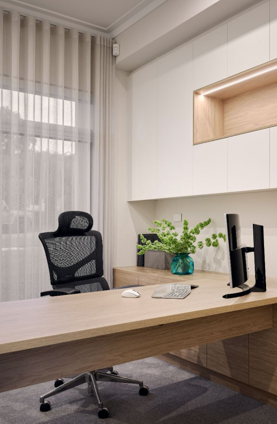 Home study at The Grove in Wembley featuring a built-in desk, shelving and a large window.