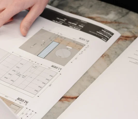 Close-up of a designer reviewing interior finish samples and architectural plans.