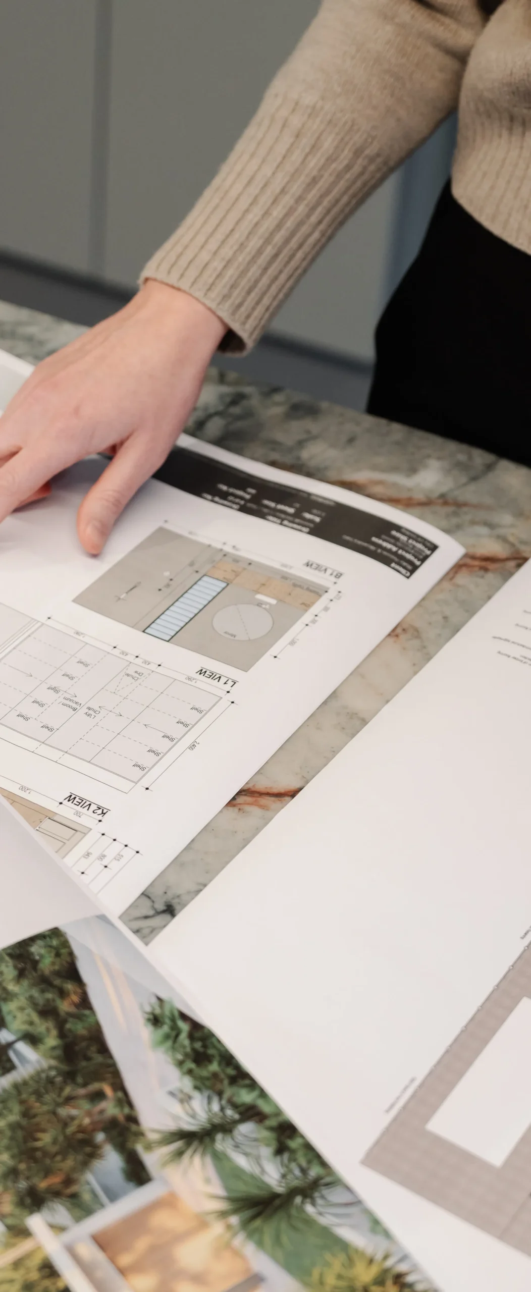 Close-up of a designer reviewing interior finish samples and architectural plans.