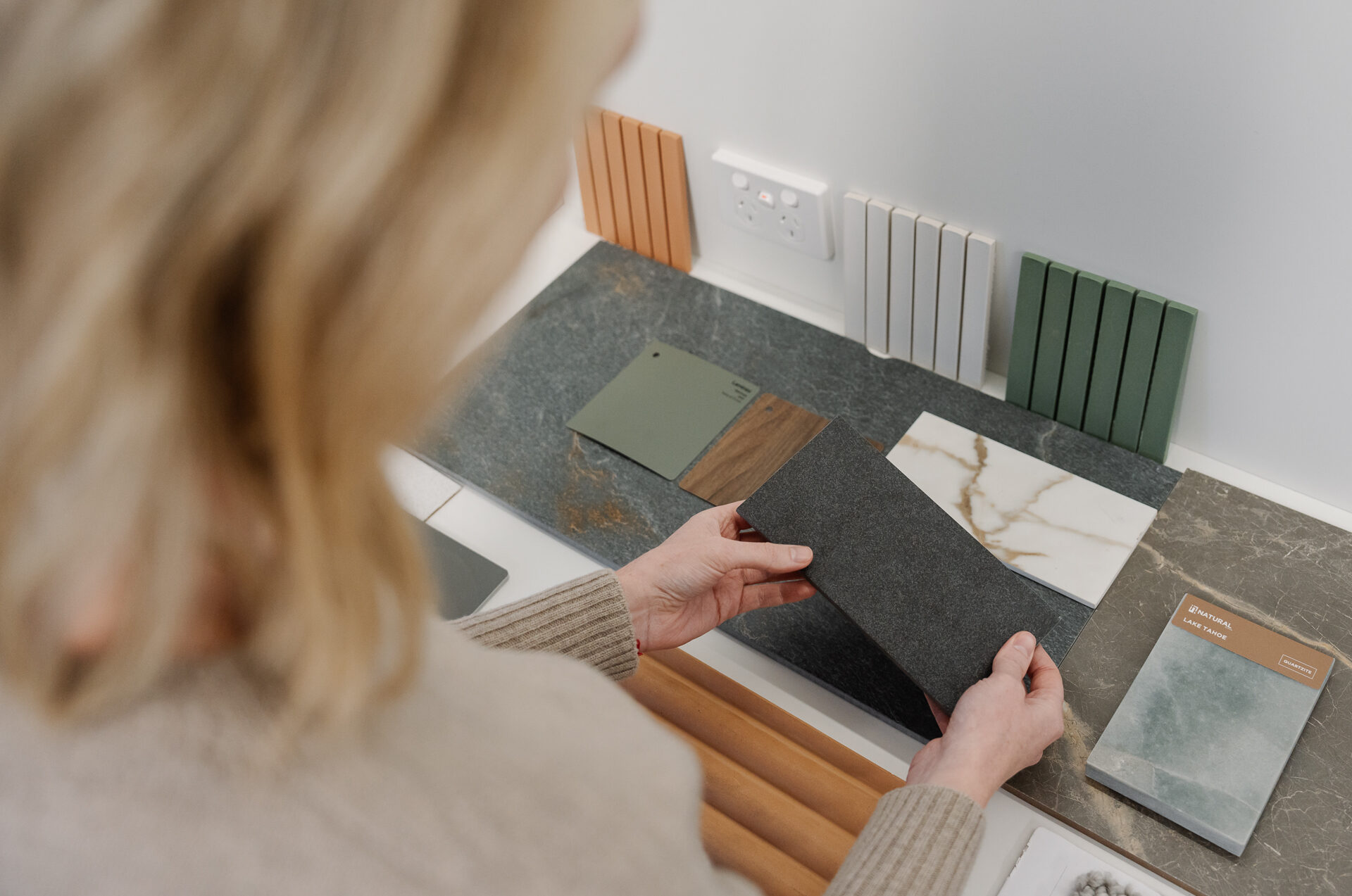 Woman selecting different colours for her custom home to avoid any common home building mistakes