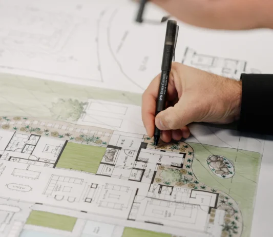 Close-up of a designer drawing on architectural floor plans during the custom home design process.