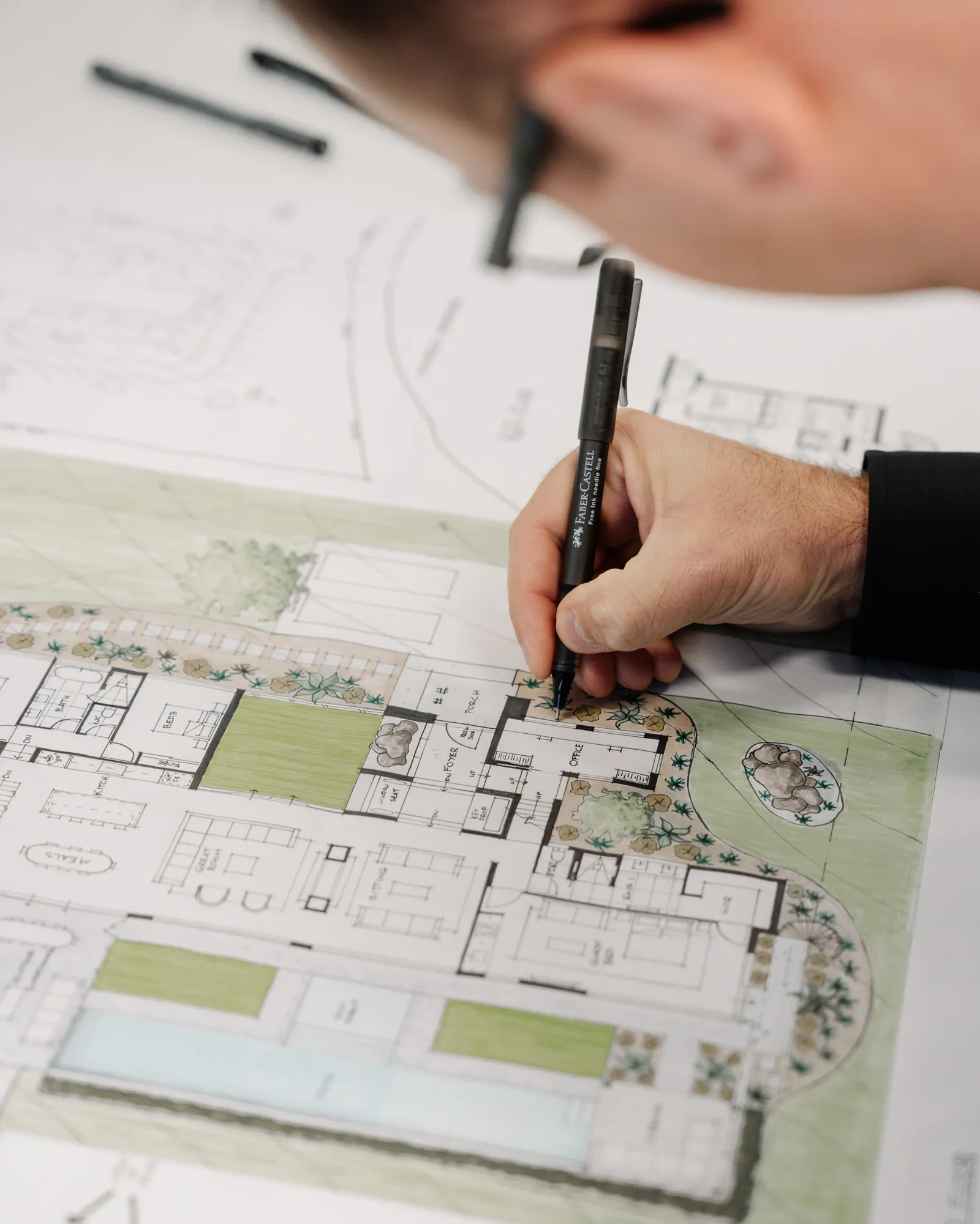 Close-up of a designer drawing on architectural floor plans during the custom home design process.