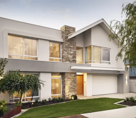 Two-storey custom home featuring pitched rooflines, stone cladding and a landscaped frontage.
