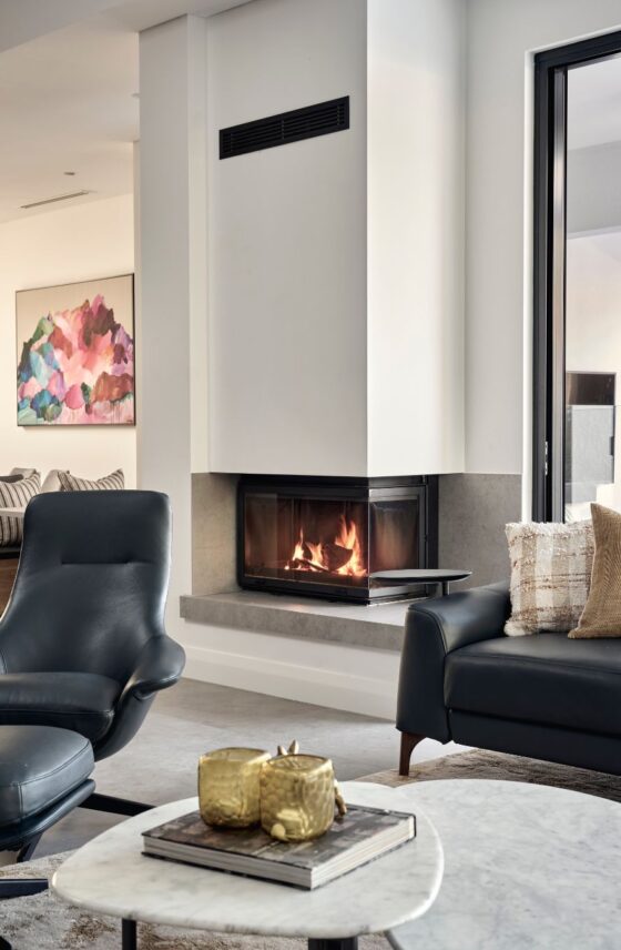 Custom home living room featuring a built-in fireplace, contemporary artwork and modern interior finishes.
