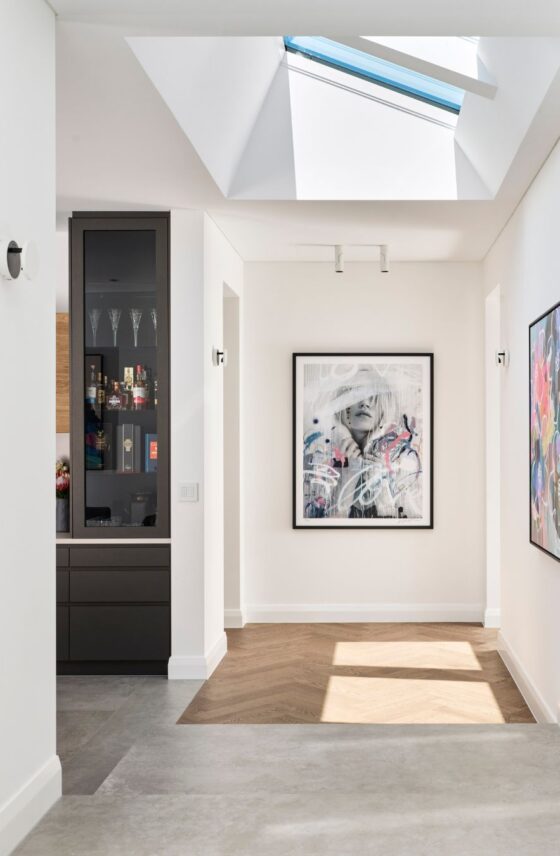 Light-filled hallway featuring skylights, white walls and contemporary artwork inside a custom-designed Perth home.