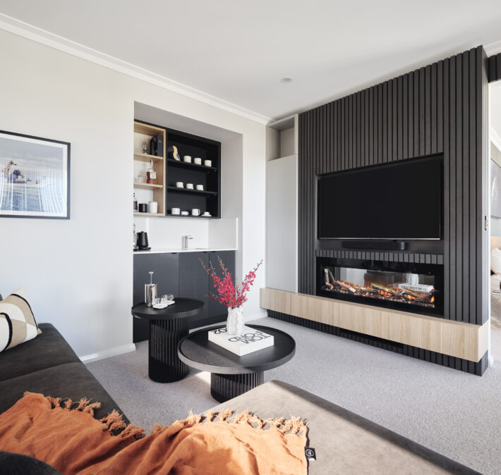 Custom home living room featuring dark timber wall panelling, built-in entertainment cabinetry and contemporary furnishings.