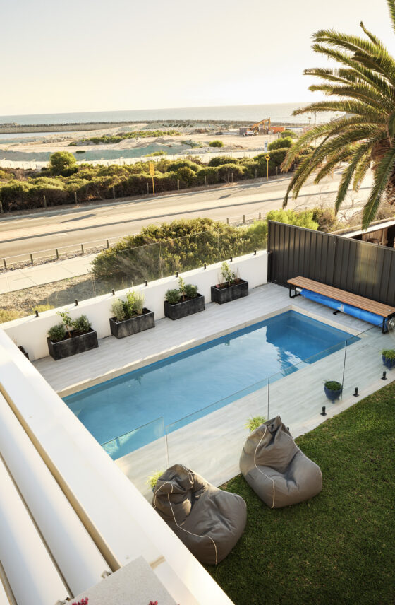 Elevated outdoor swimming pool overlooking the coastline, with landscaped surrounds and expansive ocean views.