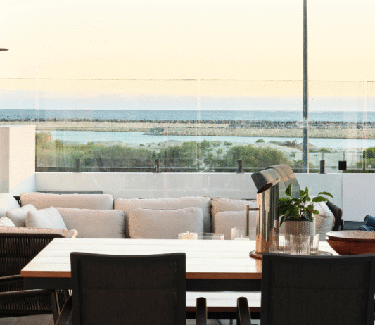 Coastal alfresco entertaining area featuring outdoor seating, timber ceiling detailing and expansive ocean views.