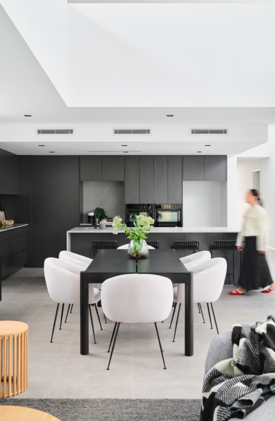 Modern custom home kitchen in Ardross with dark cabinetry, stone island benchtop and open-plan living.