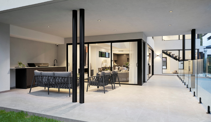Covered outdoor living area featuring a swimming pool, contemporary furniture and large sliding glass doors in Ardross.