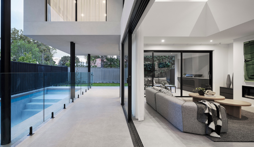 Outdoor swimming pool and alfresco area featuring expansive glazing and landscaped gardens at a custom home in Ardross.