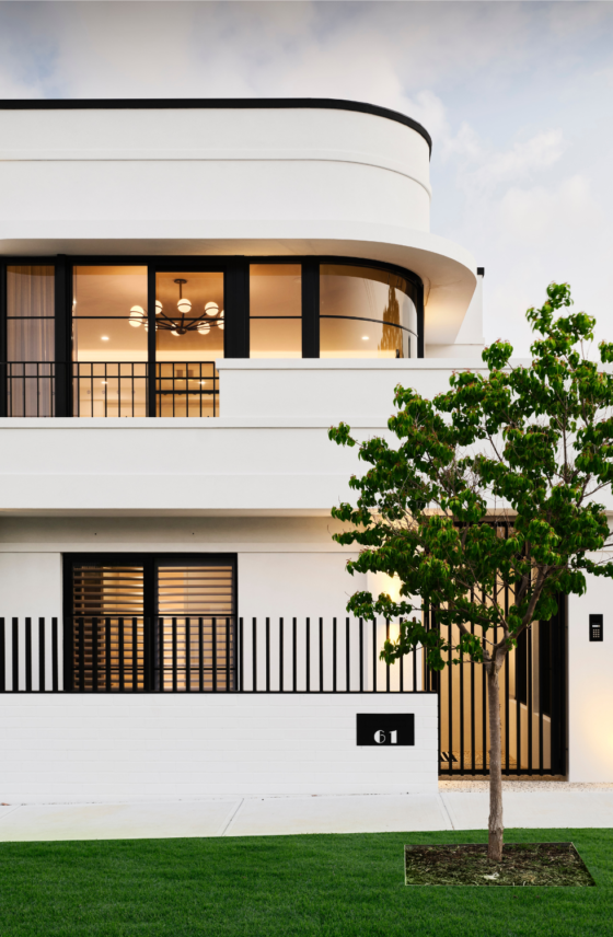 Contemporary three-storey custom home featuring curved architectural forms, expansive glazing and white exterior finishes.