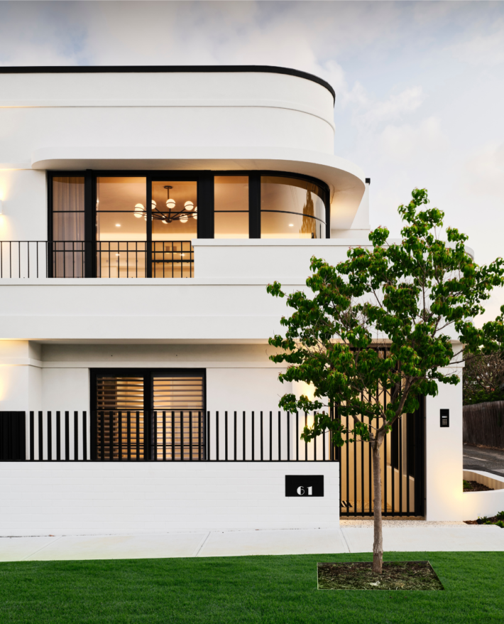 Contemporary three-storey custom home featuring curved architectural forms, expansive glazing and white exterior finishes.