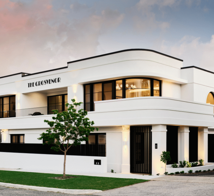 Contemporary Grosvenor custom home featuring curved exterior walls, large windows and a minimalist white facade.
