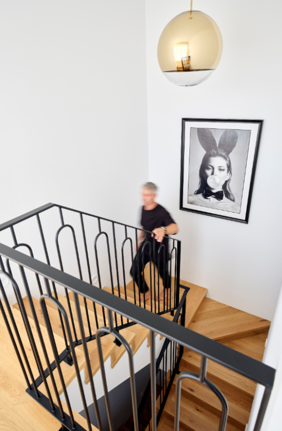 Feature pendant lighting and decorative staircase balustrade in a contemporary custom home.