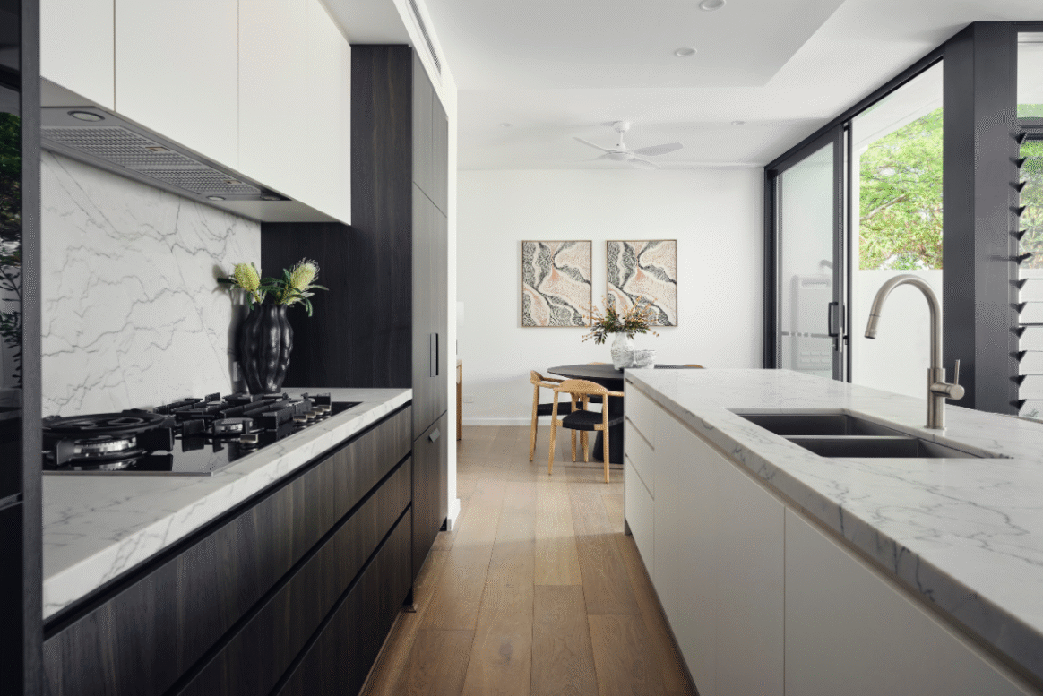 Open-plan kitchen and dining area in a Nedlands custom home featuring white cabinetry, natural light and modern finishes.