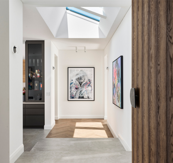 Light-filled hallway in a Marmion custom home featuring high ceilings, skylights and contemporary interior finishes.