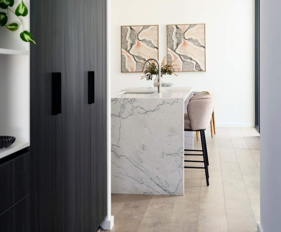 Custom home kitchen in Nedlands featuring a marble-look splashback, white cabinetry and decorative artwork.