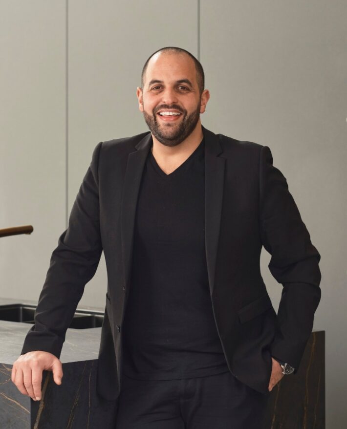Professional portrait of Trendsetter Homes director Michael Agostino standing in a contemporary interior.